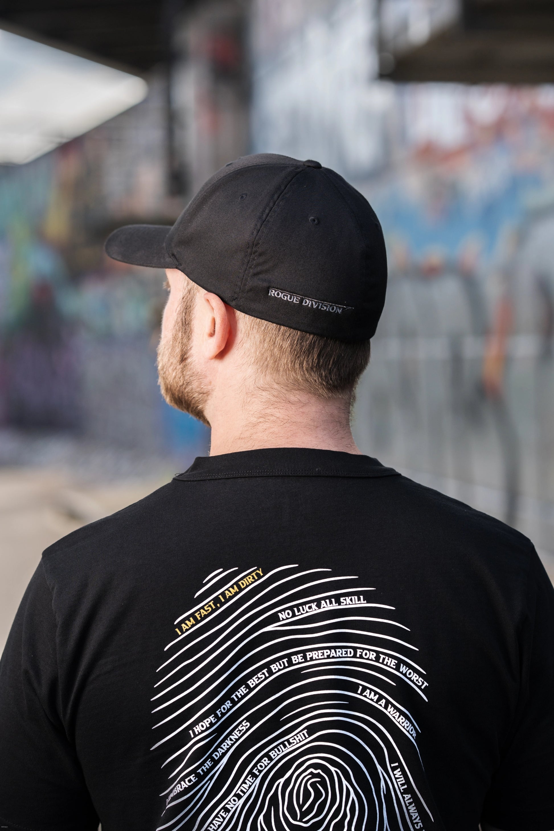 Rückseite des Fast & Dirty Gear Flexfit Cap mit Schriftzug - getragen in urbaner Umgebung