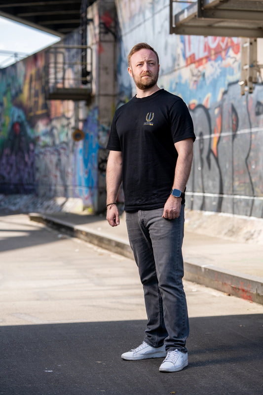 Frontaufnahme vom Fast & Dirty Gear Premium T-Shirt mit detailliertem Logo auf der Brust in urbaner Umgebung 